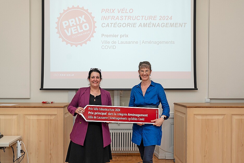 La conseillère municipale de la Ville de Lausanne en charge de la mobilité, Florence Germond (à droite), reçoit le Prix Vélo Infrastructure 2024 des mains de la vice-présidente de PRO VELO Suisse, Delphine Klopfenstein, lors de la remise des prix.