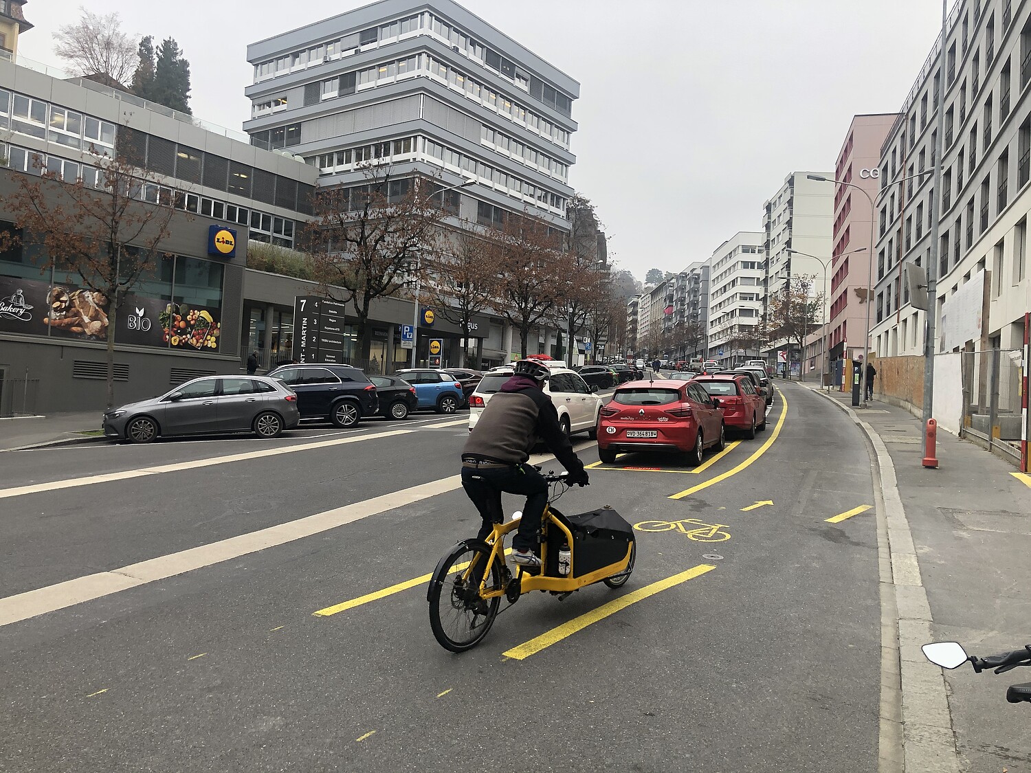 Lausanne, rue Saint-Martin: la nouvelle bande cyclable, située derrière une rangée de places de parc, sépare l’espace cyclable de celui des véhicules motorisés et augmente ainsi le sentiment de sécurité.